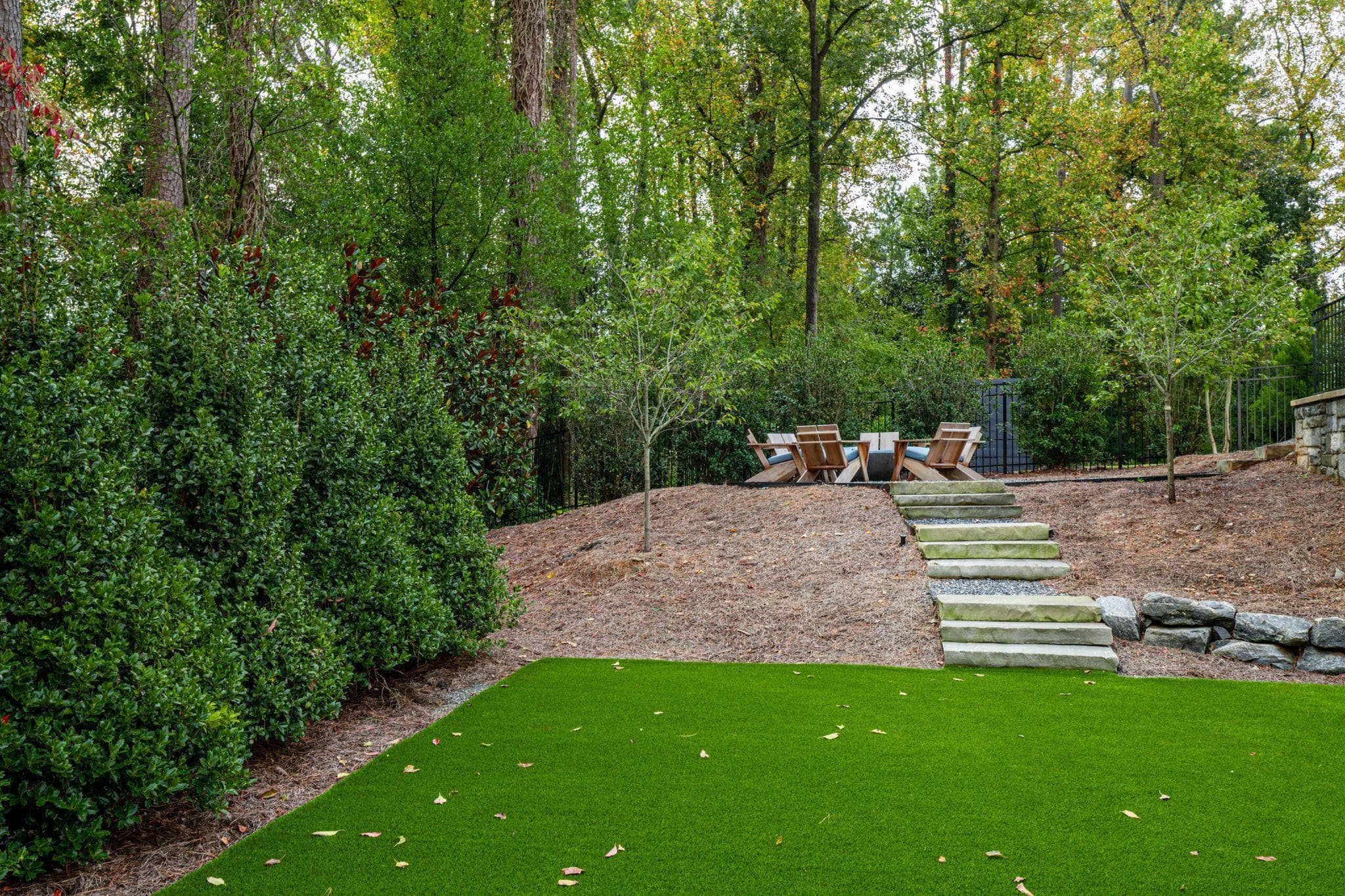 Terraced backyard with stone steps leading to fire pit seating area